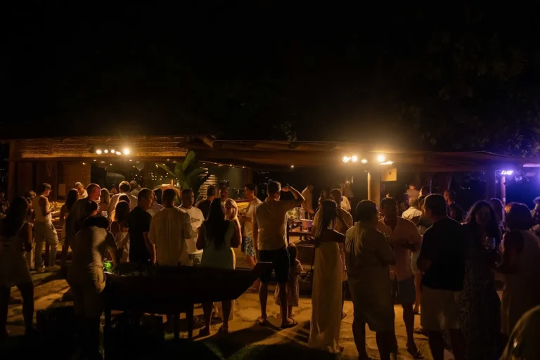 A casa cheia à noite, com o varal de luzes e a pista ao fundo