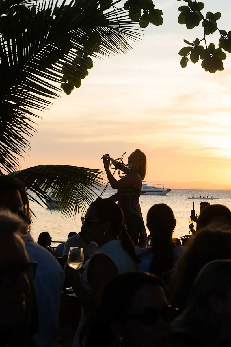 A violinista Karen Machado em silhueta, tocando diante do pôr do sol no Wine Festival Obar 2026